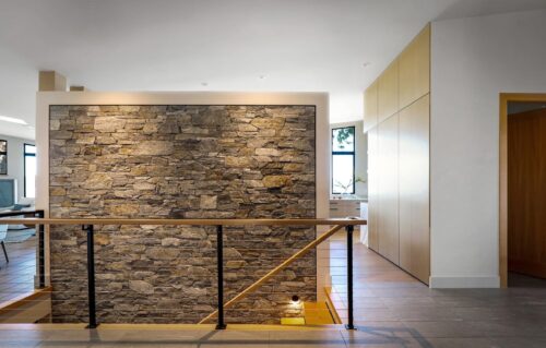 Stonework by Central Masonry | Home by Facet Builders | Photo by LSP Media Interior facing natural stone veneer on feature wall along stairs, using K2 Stone Ocean Mist mixed with Natural Ledge stone - Comox BC