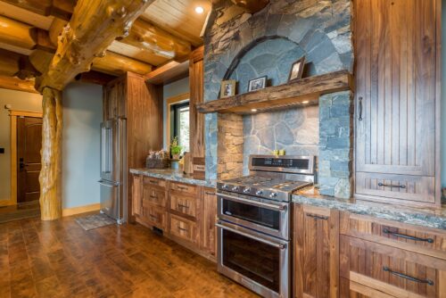 Stonework by Central Masonry | Home by Facet Builders | Photo courtesy of Facet Builders Custom stone kitchen feature wall and archway, using K2 Stone, in a log home built by Facet Builders - Comox Valley BC